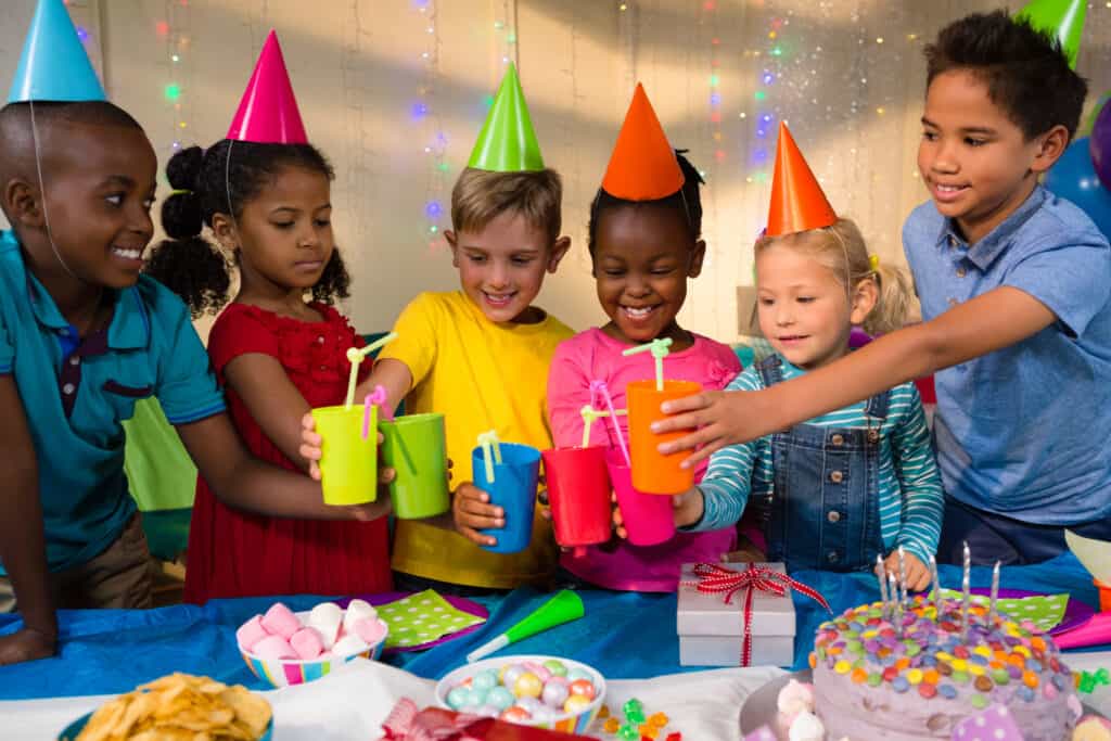 Happy children toasting drinks during birthday party